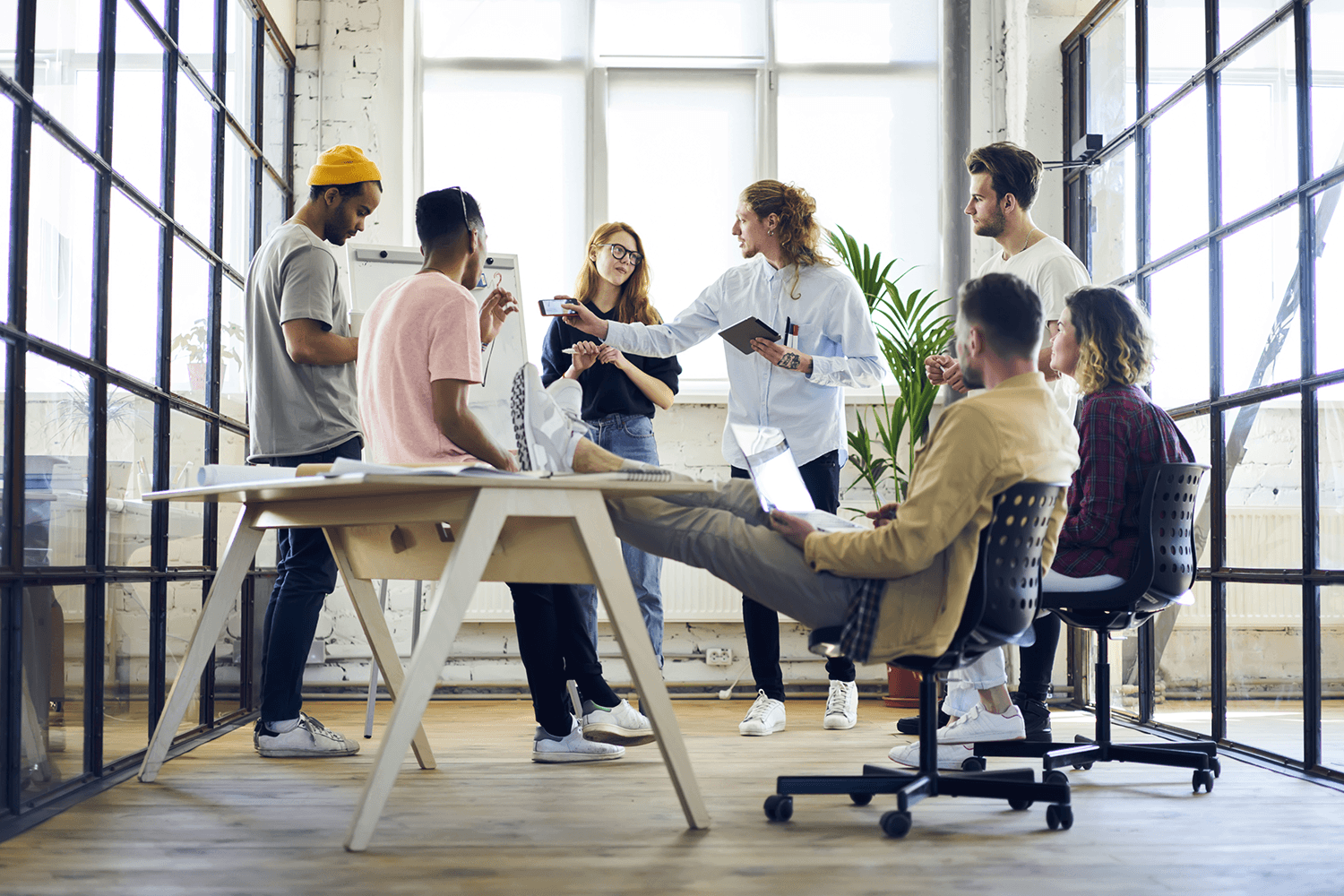 PR team collaborating around a table in a bright office, planning the story and media list behind a pitch