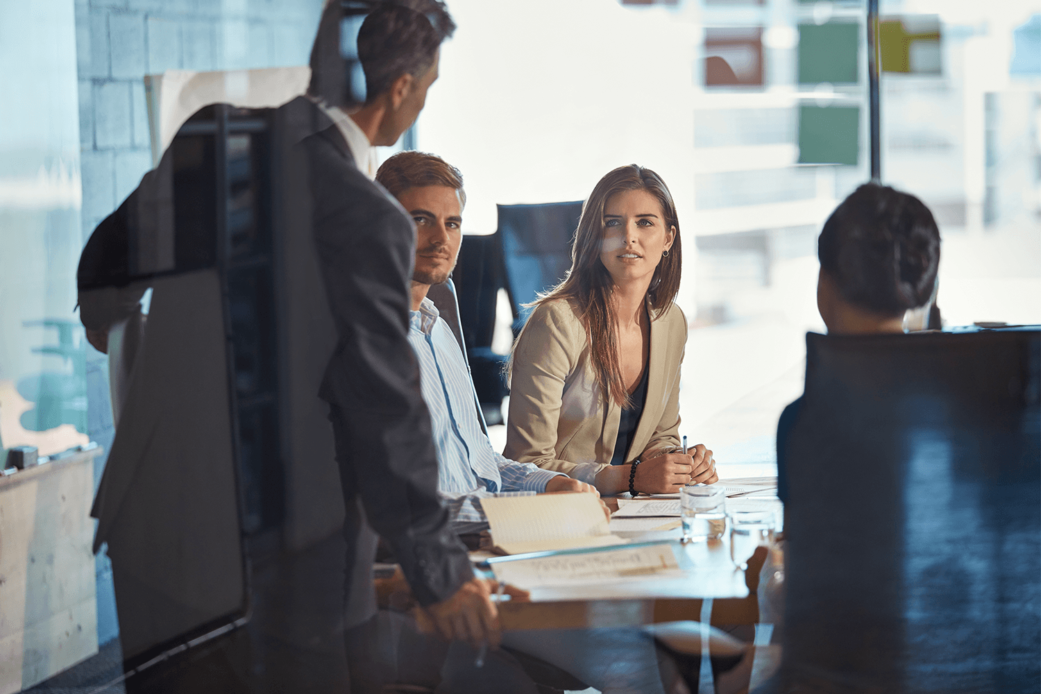 Man hosting a meeting with a group of others listening