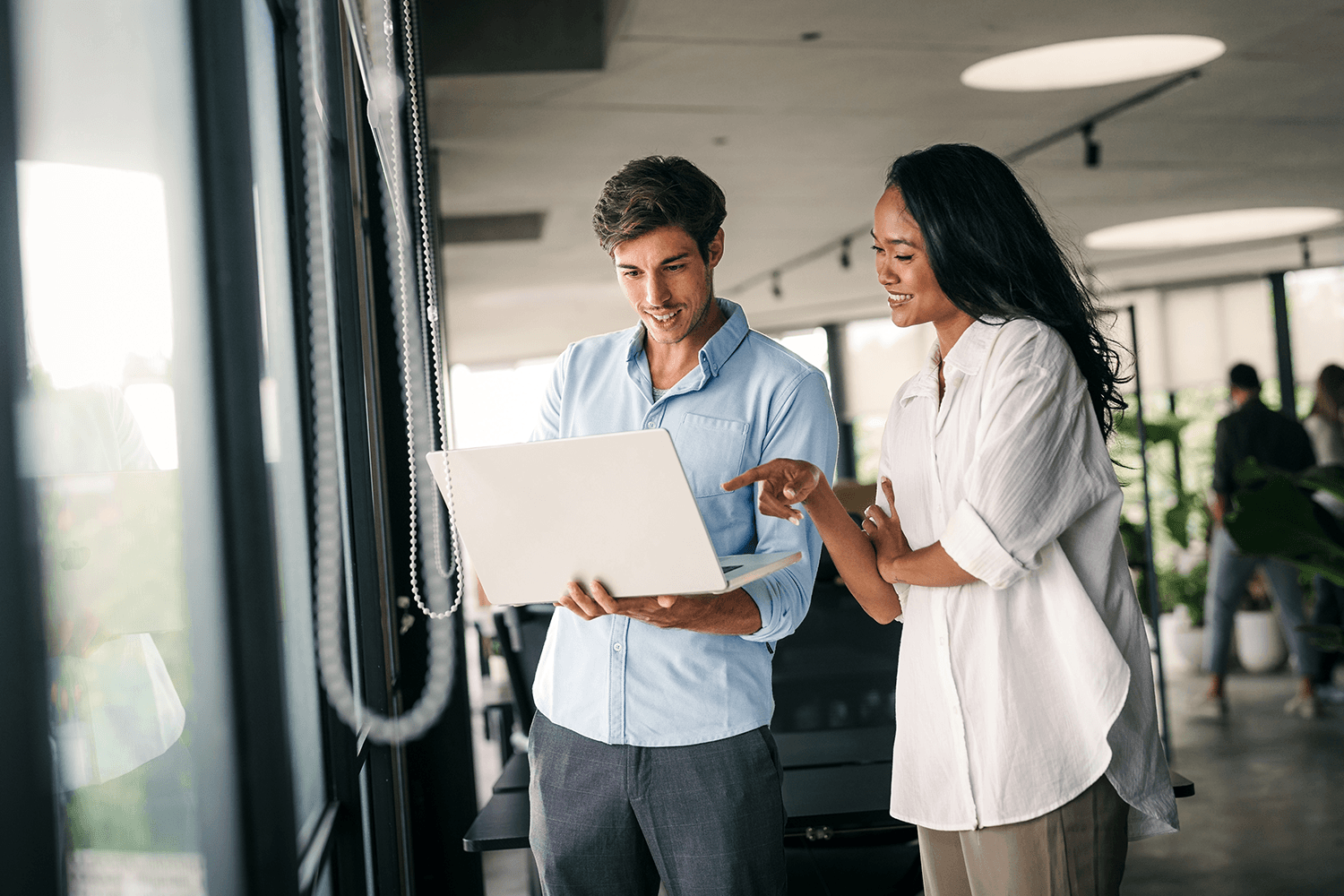 Two professionals reviewing content on a laptop, symbolizing how effective content strategy aligns user needs with both link earning and conversion goals.