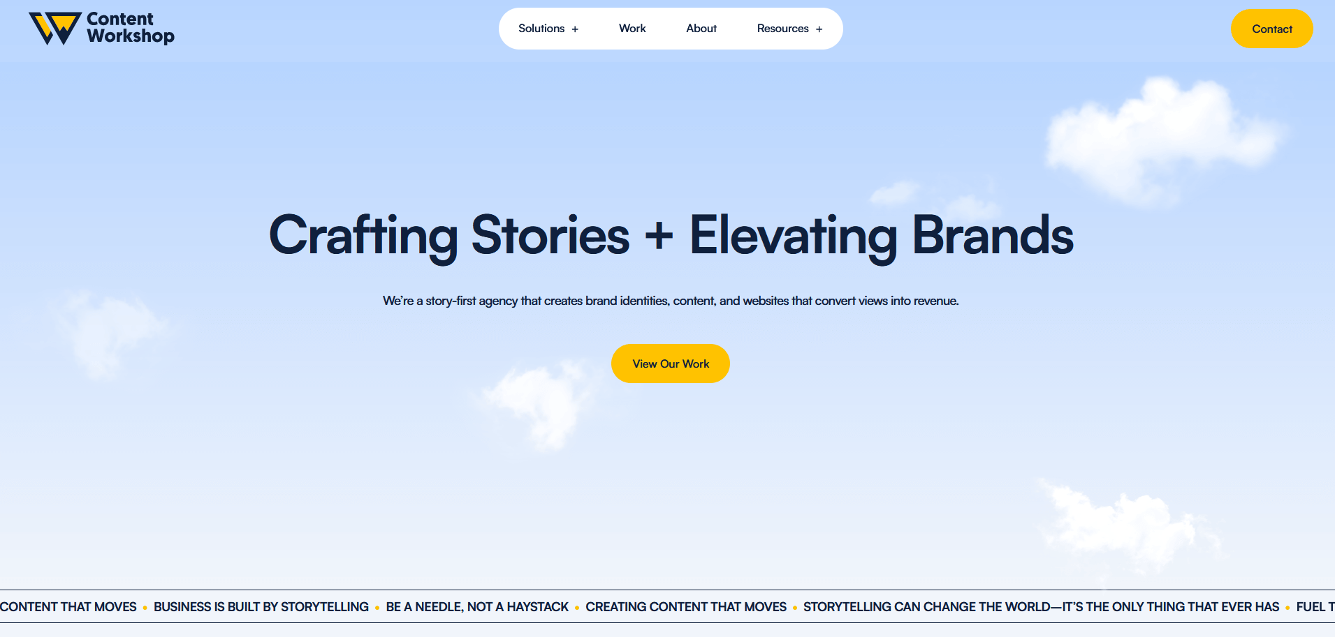 A website homepage features the headline “Crafting Stories + Elevating Brands” centered against a blue sky background with white clouds. The tagline below describes the agency as “story-first,” and a yellow “View Our Work” button is prominently displayed beneath the text.