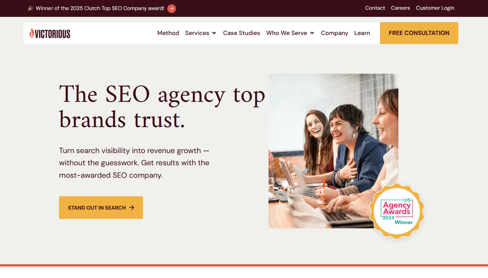 A website homepage features the headline “The SEO agency top brands trust” with supporting text about turning search visibility into revenue growth. To the right, a photo shows three smiling women collaborating at a laptop, next to a “US Agency Awards 2024 Winner” badge.